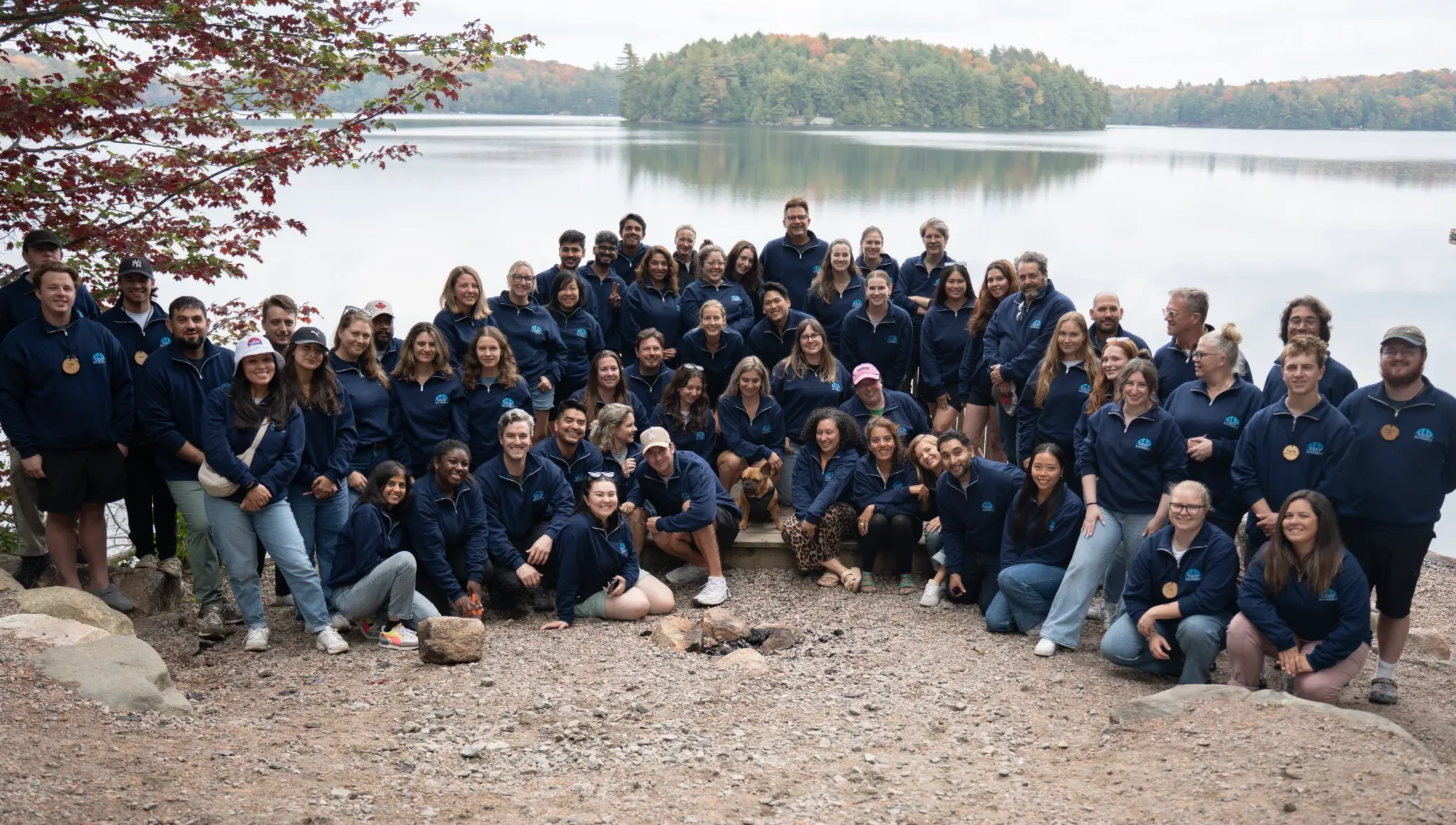 A group connecting outdoors beside a lake on an autumn day